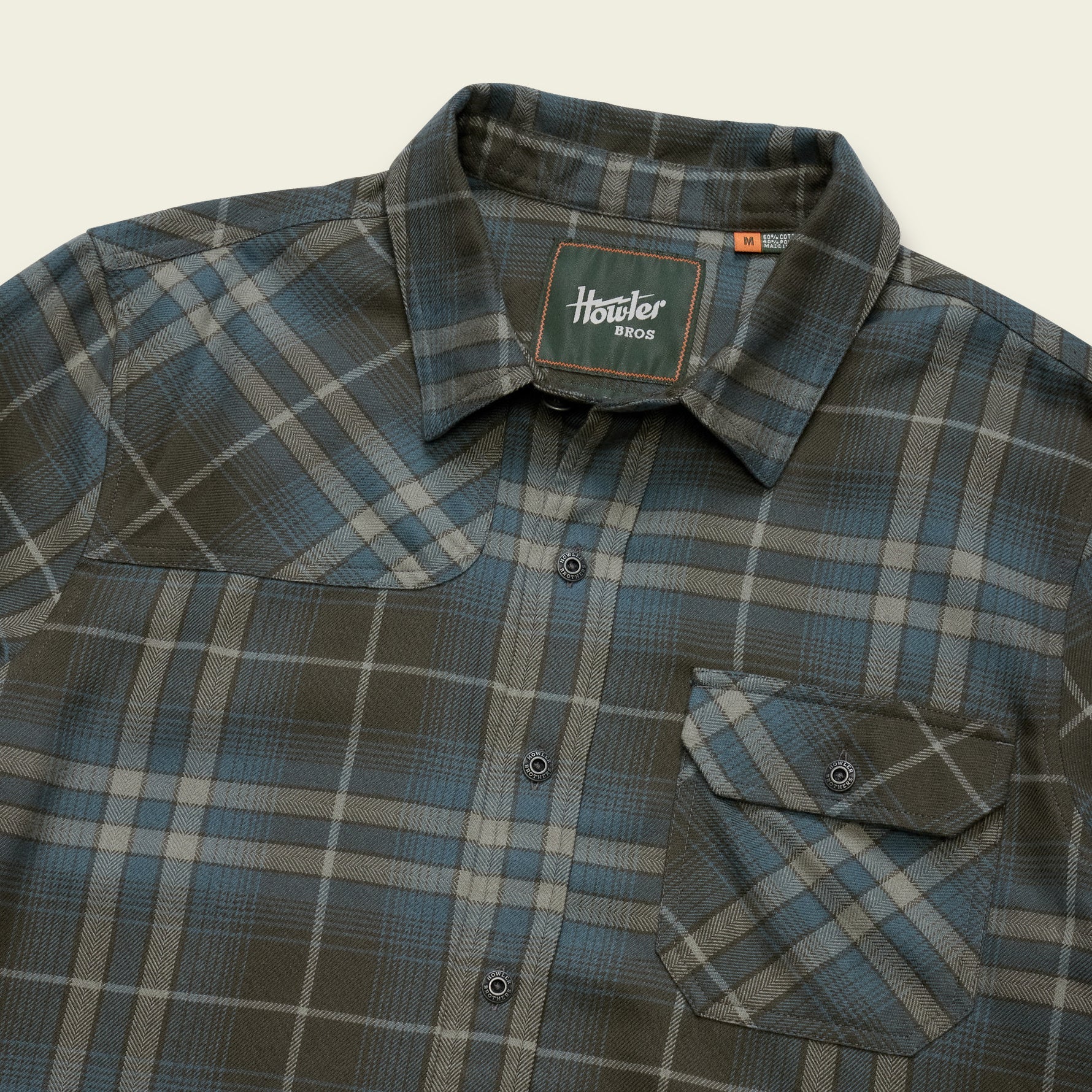 Men's plaid flannel shirt detail shot showing collar, snap buttons, and chest pocket