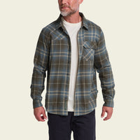 Men's plaid flannel shirt in olive and blue, worn open over white tee, front view