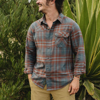 Men's plaid flannel shirt in blue-gray and rust tones, on-model lifestyle shot, front view