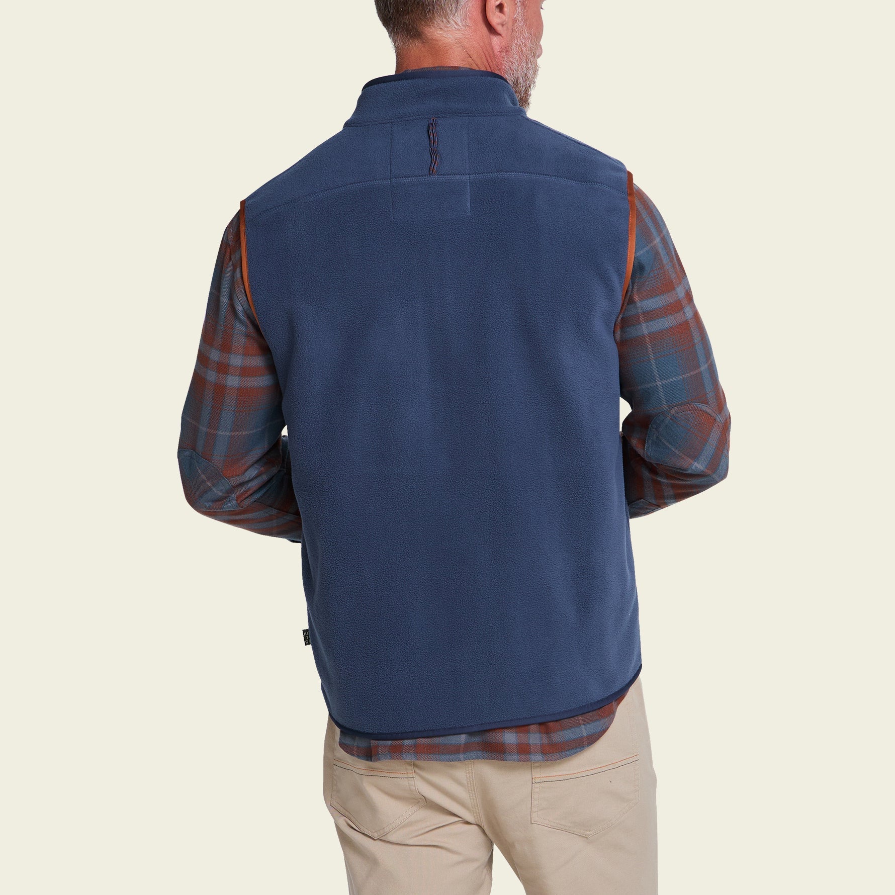Men's fleece vest back view, worn over plaid flannel shirt with khaki pants