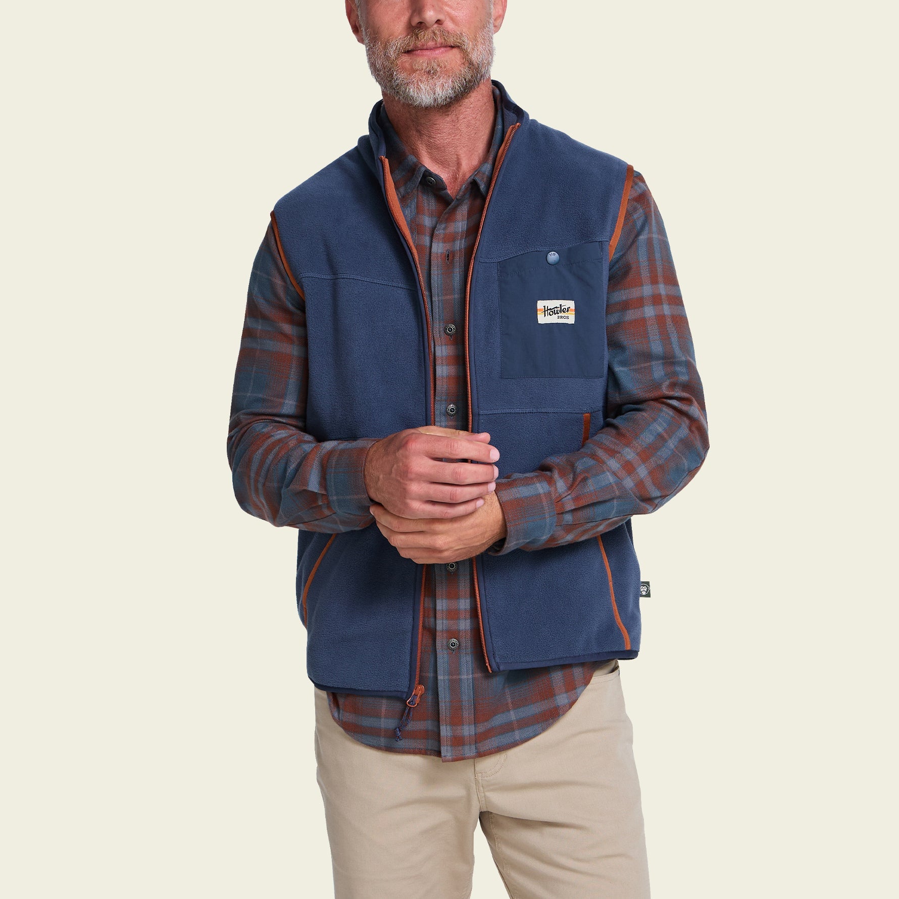 Men's fleece vest in dark navy with contrast trim, worn over plaid shirt, front view