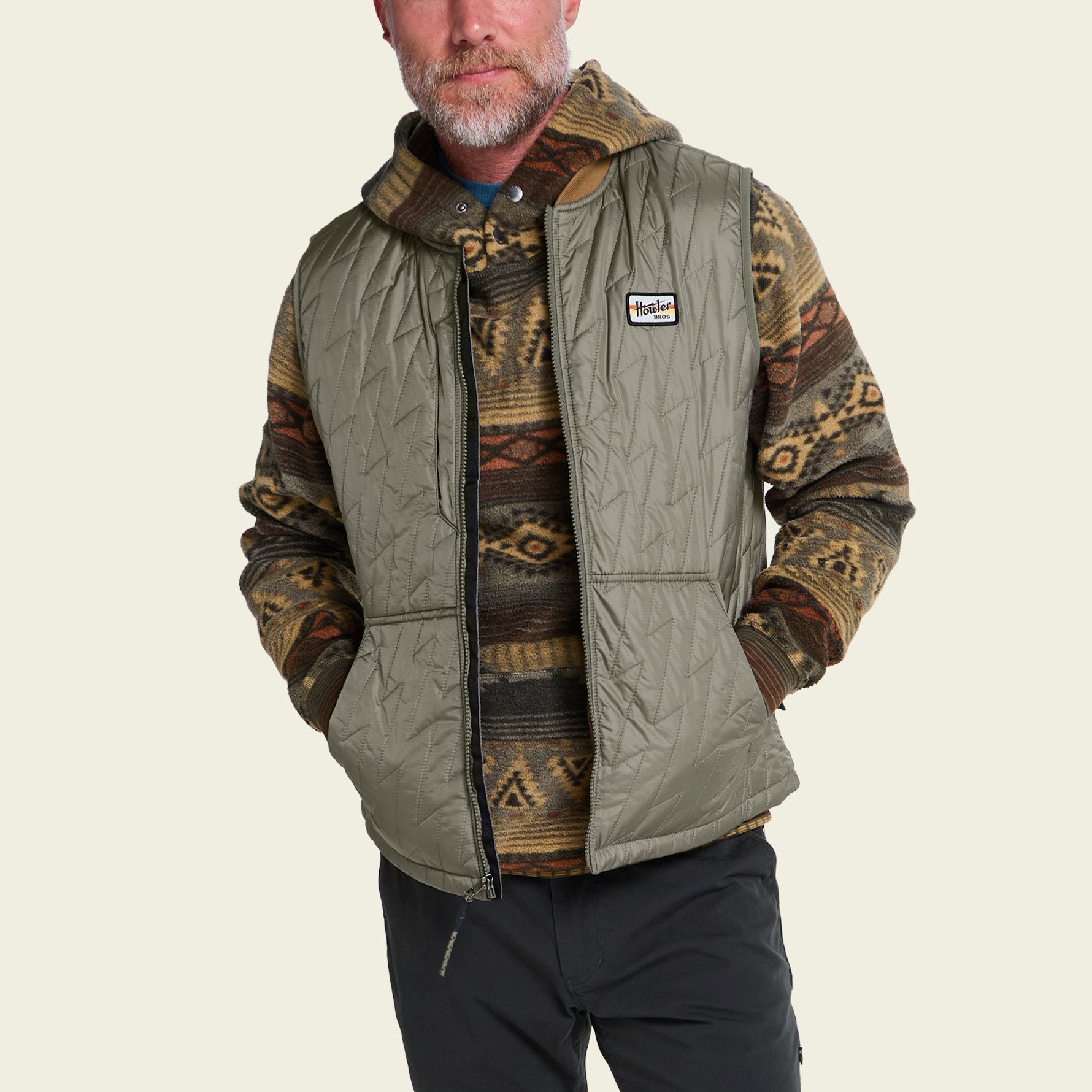 Men's quilted sleeveless vest in olive green with diamond stitching, front view on model