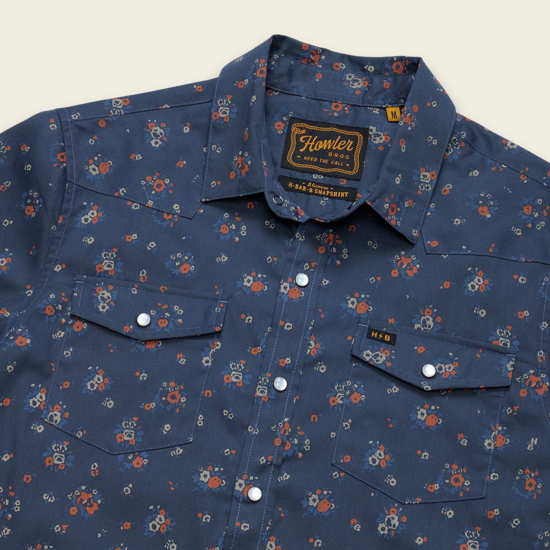 Men's western snap shirt in navy floral print with pearl snaps and dual chest pockets, angled view