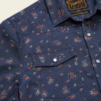 Close-up detail of a navy floral western snap shirt with dual chest pockets and silver snaps