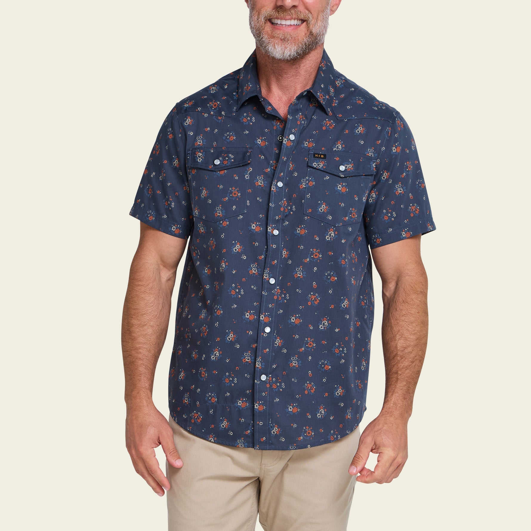 Men's short-sleeve navy floral snap-button shirt with chest pockets, front view on model