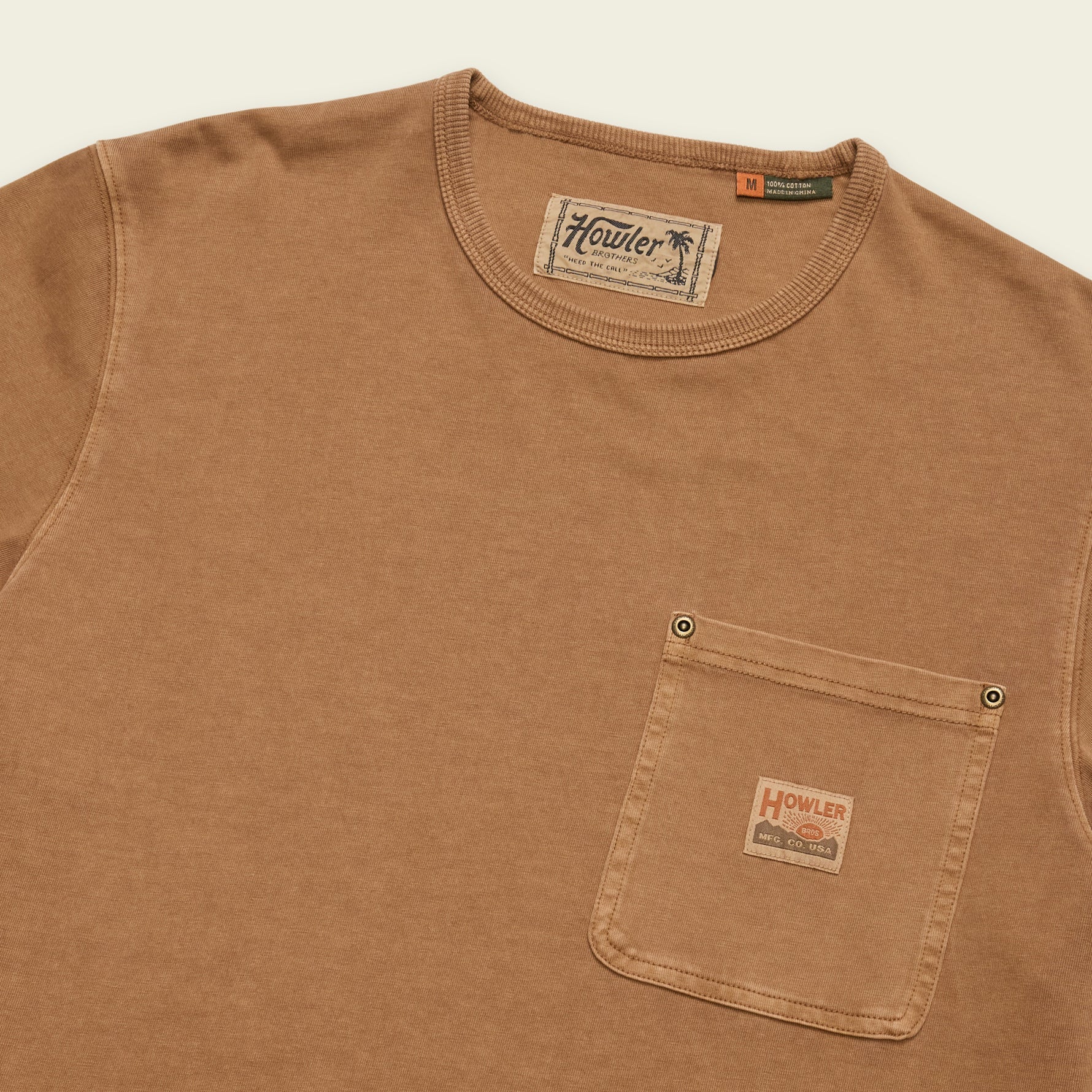 Tan cotton crew-neck t-shirt with chest pocket and woven logo patch, angled view