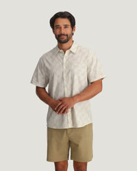 Light colored short sleeve button-up shirt with subtle pattern, front view on male model
