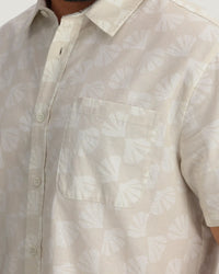 Light colored linen button-up shirt with chest pocket and subtle shell print pattern