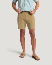 Man wearing khaki hybrid shorts with light blue button-up shirt and leather sandals