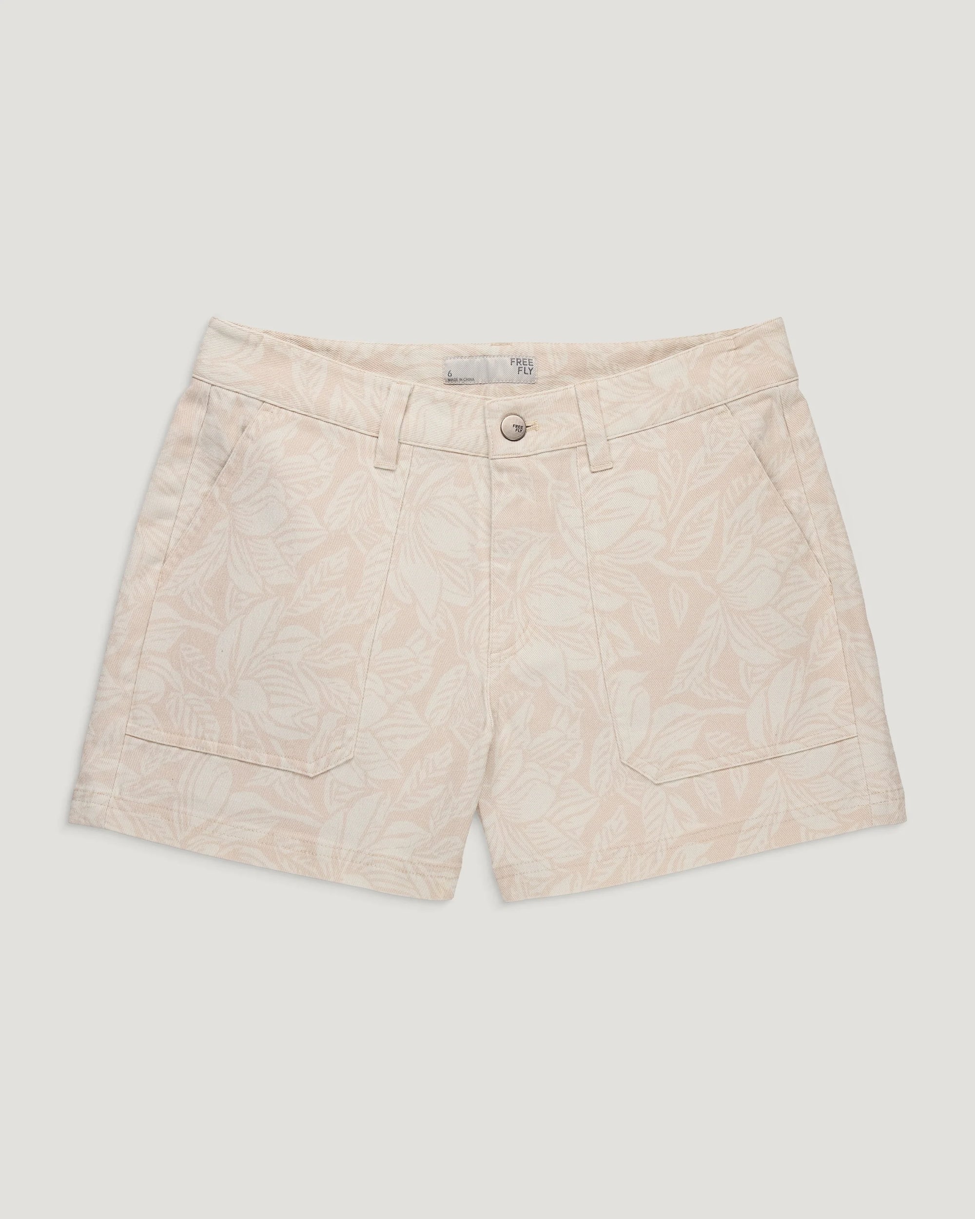 Light colored twill shorts with tropical print, front view showing pockets and button closure