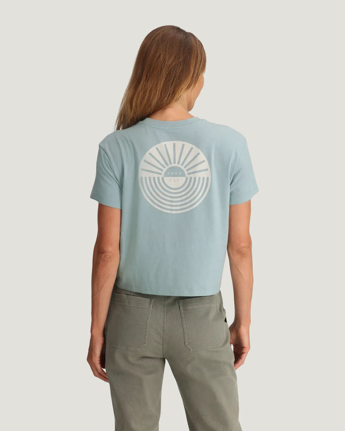 Light blue cropped t-shirt with circular sun and wave graphic on back, rear view