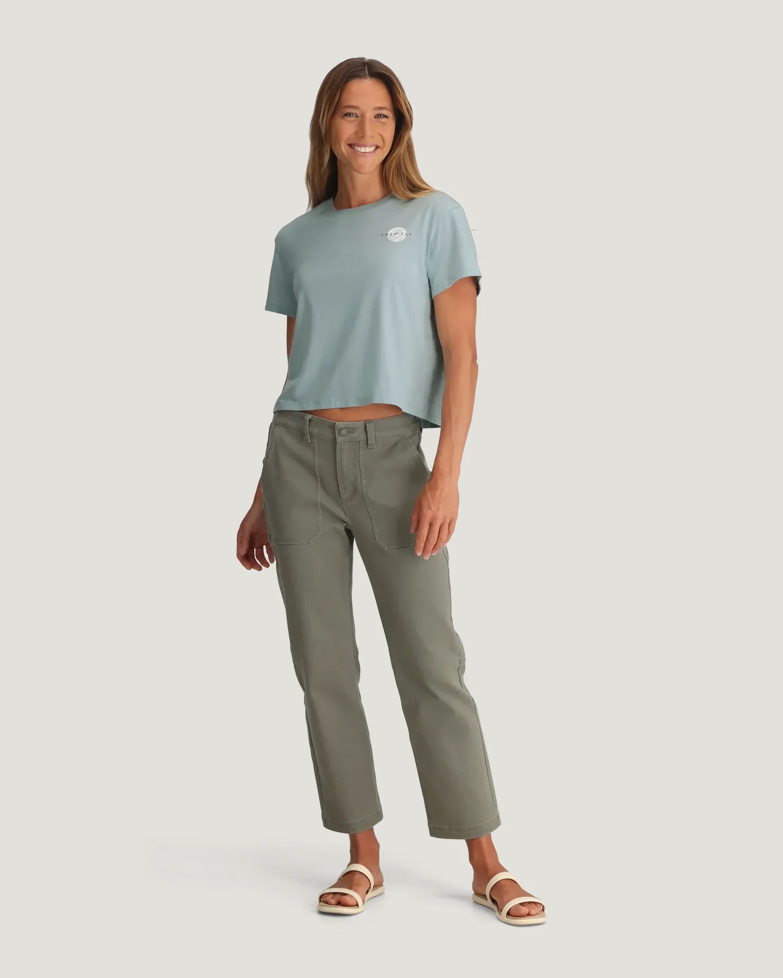 Light blue cropped t-shirt with small logo, worn with olive green pants on model