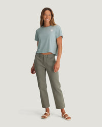 Light blue cropped t-shirt with small logo, worn with olive green pants on model