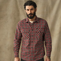 Men's plaid flannel shirt in red tartan pattern with dual chest pockets, front view on model