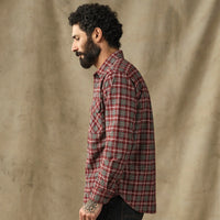 Men's plaid flannel shirt in red tartan, side profile view on bearded model