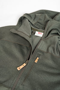 Olive green fleece hoodie with full zip closure and wooden zipper pulls, angled view