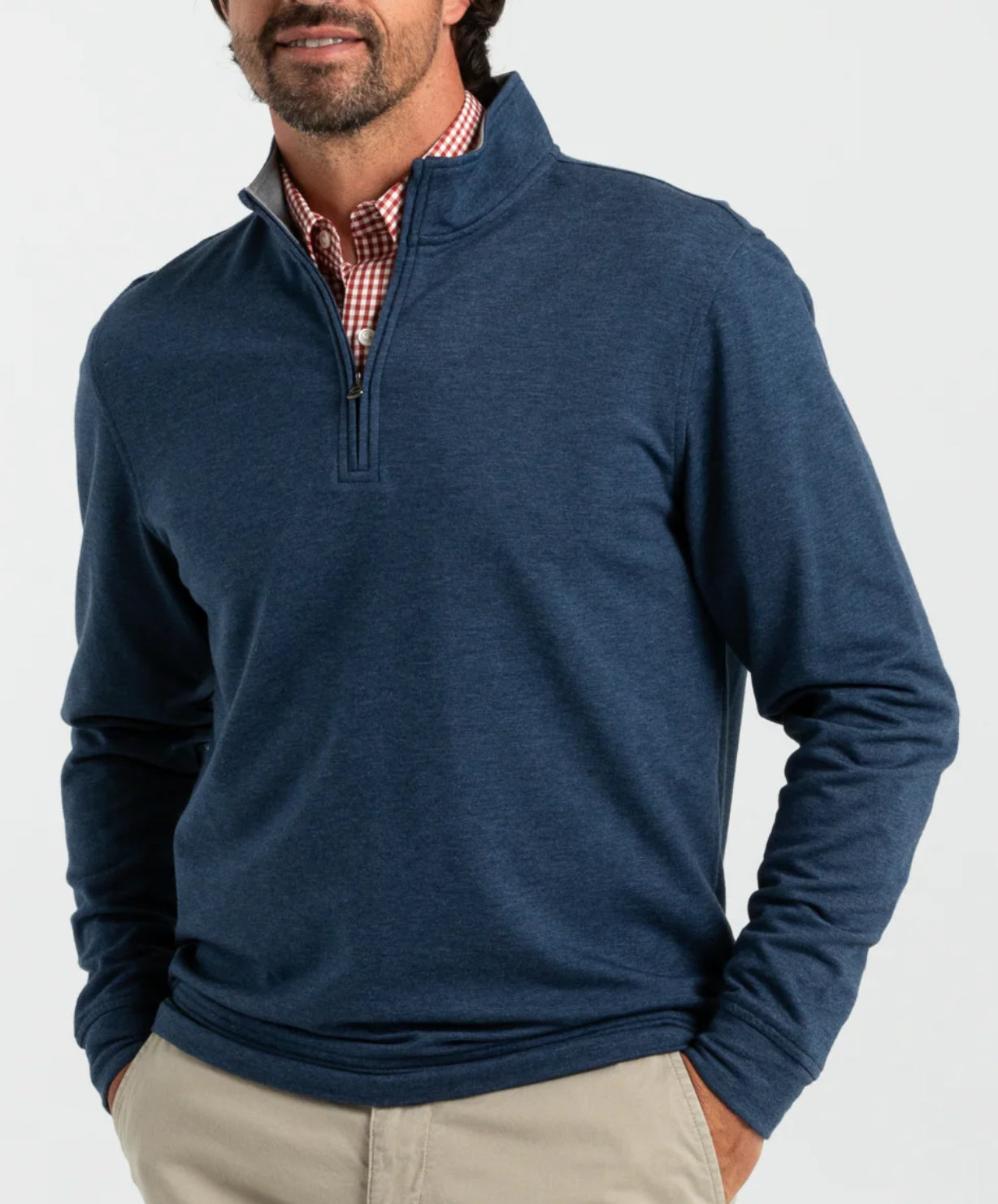 Man wearing heathered navy quarter-zip pullover over red checkered shirt with khaki pants