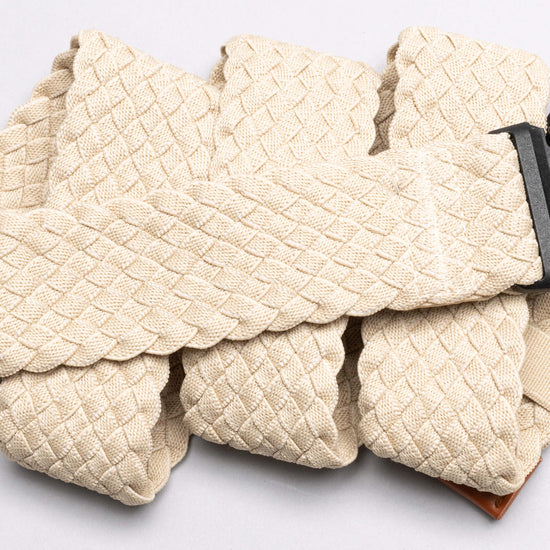 Light beige woven belt with braided texture pattern laid flat on white background