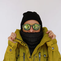 Black quilted neck gaiter worn on model, pulled up over chin and lower face