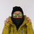 Black quilted neck gaiter worn on model, pulled up over chin and lower face