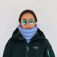Light blue quilted neck gaiter worn as a neck warmer on a model in a winter jacket