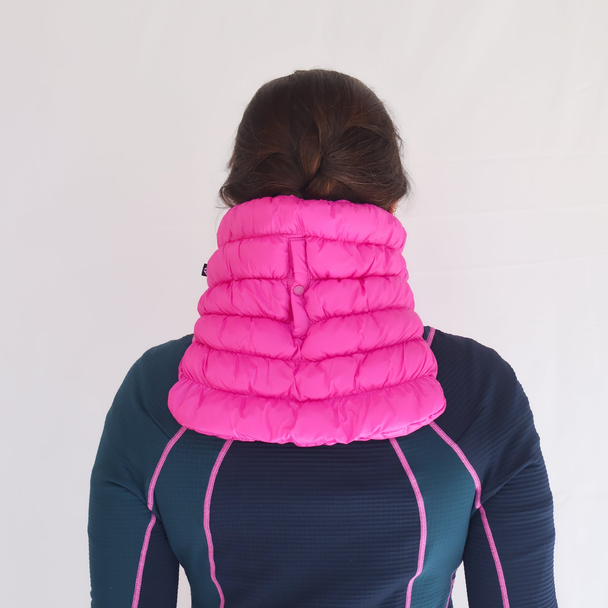 Bright pink quilted puffer neck gaiter worn by model, back view showing full coverage