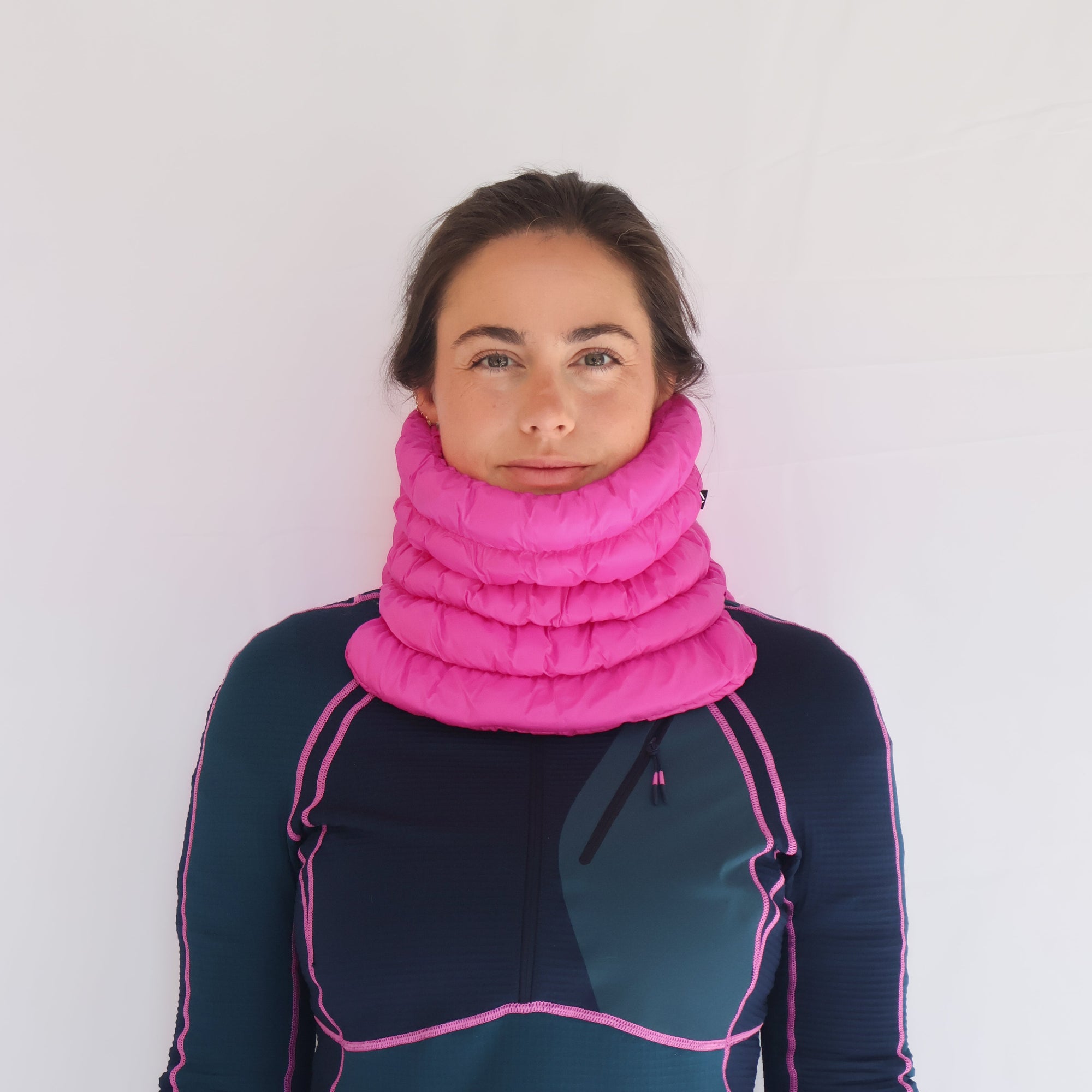 Bright pink quilted neck gaiter worn by model, front view, puffy tubular design