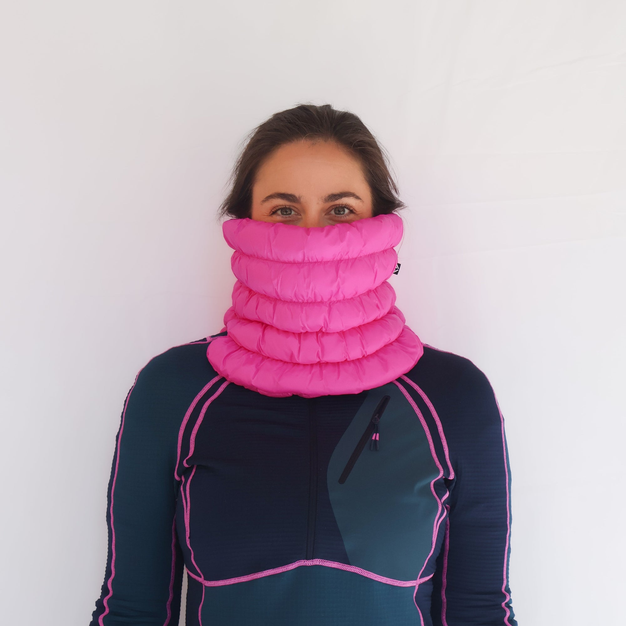 Bright pink quilted puffer neck gaiter worn pulled up over nose, front view on model
