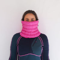 Bright pink quilted puffer neck gaiter worn pulled up over nose, front view on model