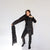 Model holding and wearing a long black quilted puffer scarf, full length view