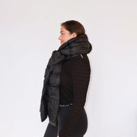 Black quilted puffer scarf worn draped around neck and shoulders, side view on model