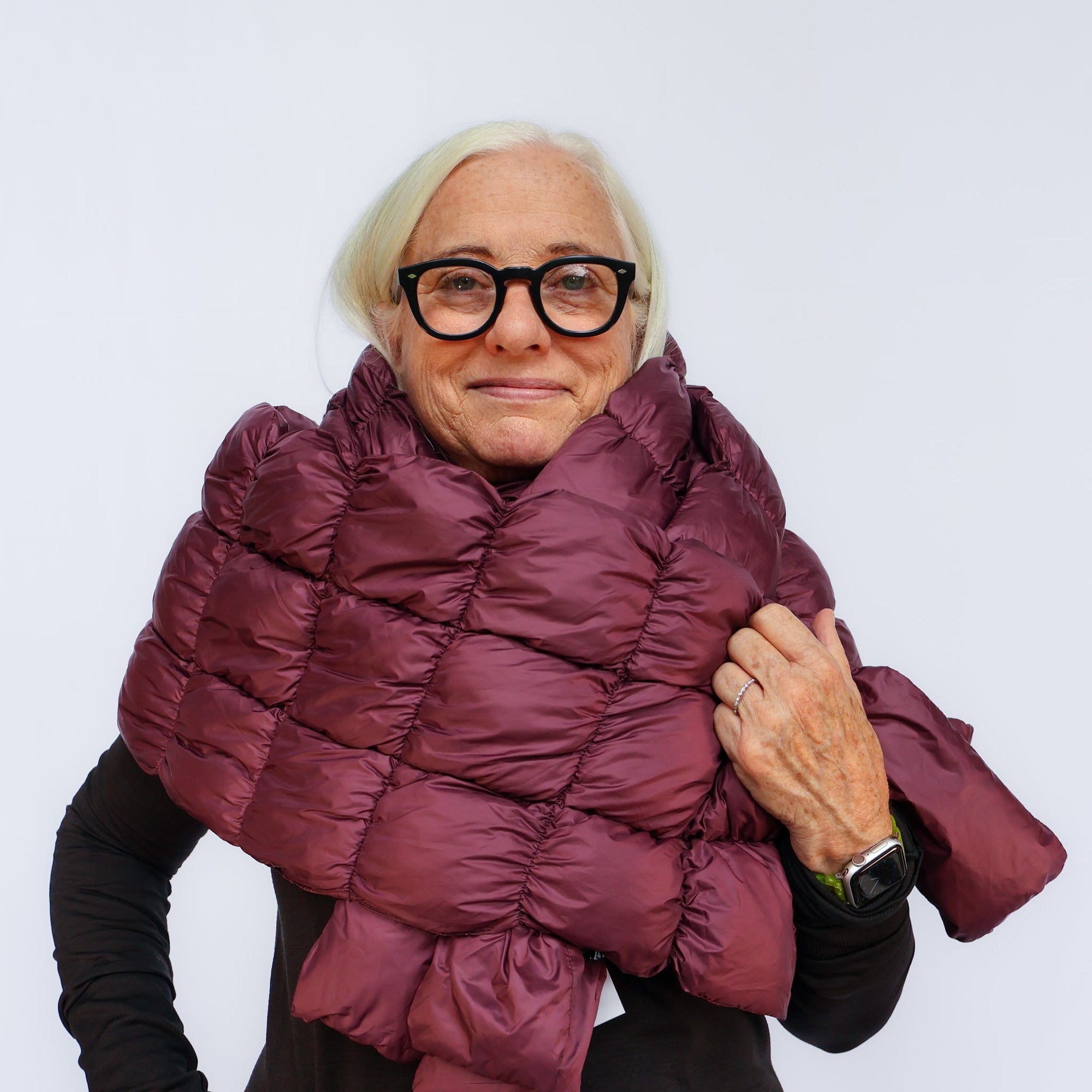 Woman wearing a quilted puffer scarf wrapped around neck and shoulders, front view
