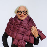Woman wearing a quilted puffer scarf wrapped around neck and shoulders, front view