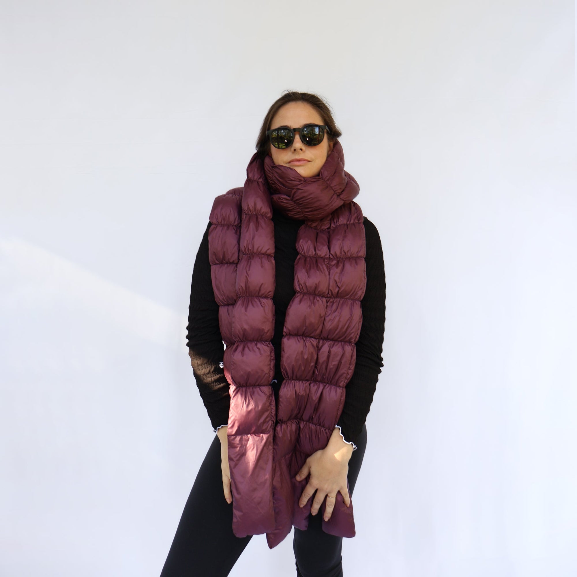 Long quilted puffer scarf in deep plum, worn wrapped around neck, front view on model