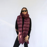 Long quilted puffer scarf in deep plum, worn wrapped around neck, front view on model