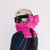 Bright pink puffer ski helmet bow and neck gaiter worn with white ski helmet, side view