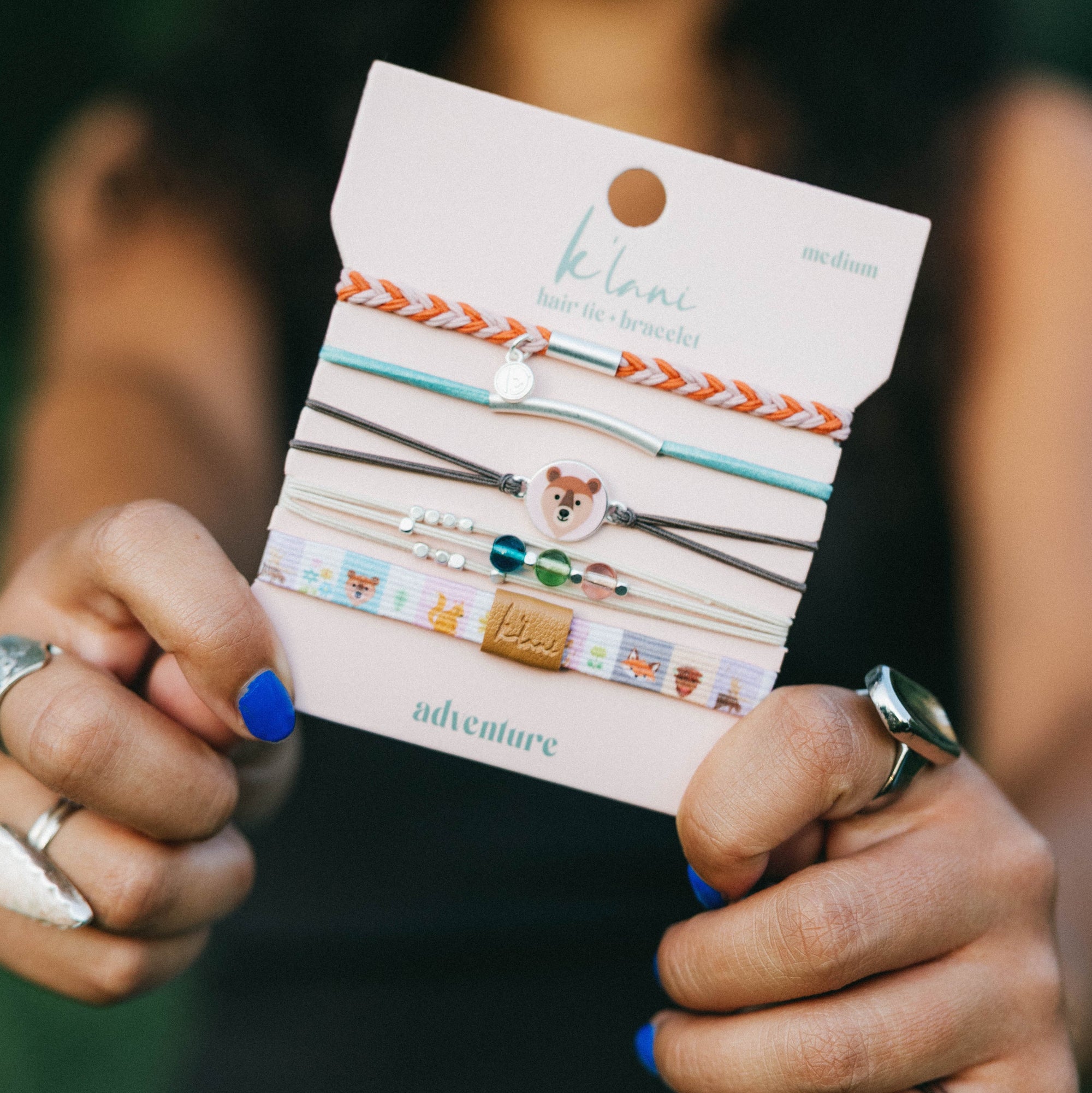 Set of five hair tie bracelets on display card featuring bear charm, beads, and braided designs