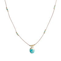 Delicate cord necklace with turquoise stone pendant, gold cap, and small scattered beads