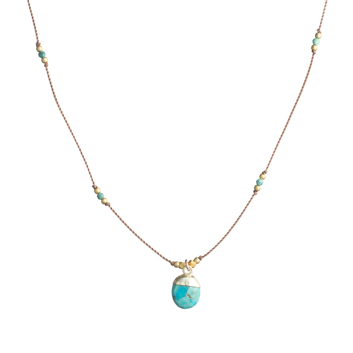 Delicate cord necklace with turquoise stone pendant, gold cap, and small scattered beads