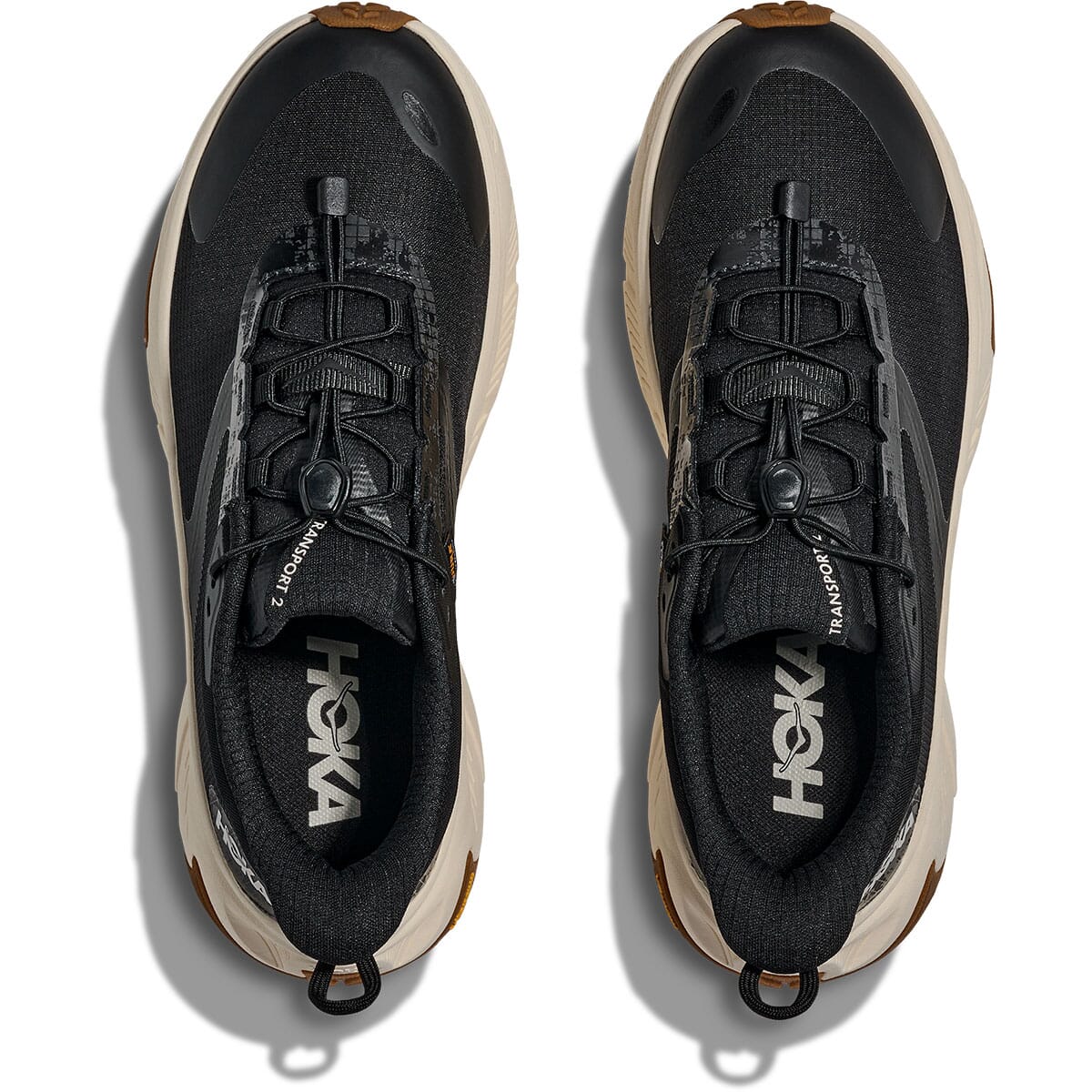Black athletic running shoes with toggle lacing system and tan midsole, top-down view