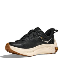 Black athletic running shoe with cream midsole and brown rubber outsole, side profile view