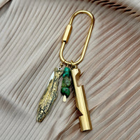 Gold brass carabiner purse charm with fish knife, turquoise stones, and cylindrical whistle pendants
