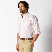 Light pink long sleeve oxford button-up shirt on male model with rolled sleeves