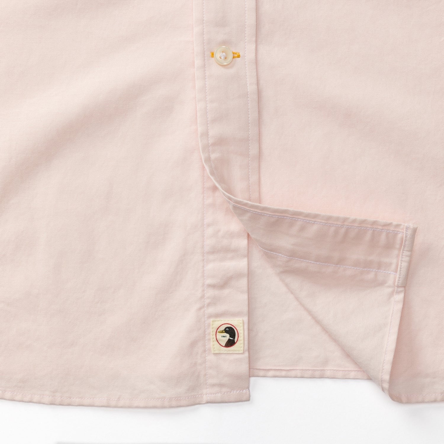 Light pink long sleeve oxford shirt showing chest pocket and button details