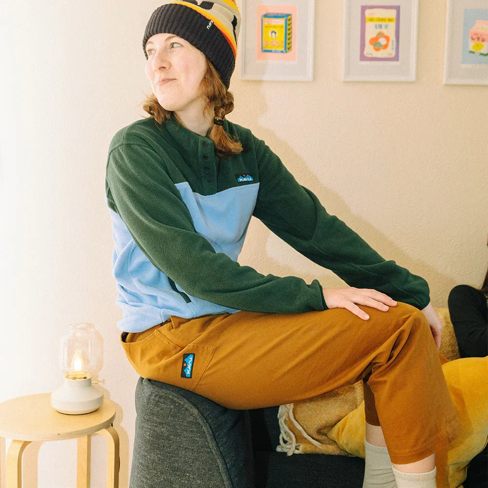 Woman wearing colorblock fleece pullover with quarter-zip collar in lifestyle indoor setting