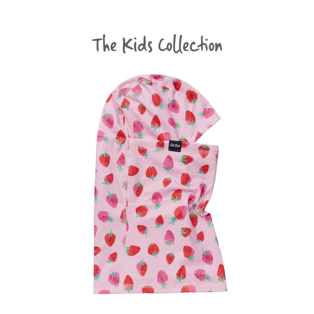 Kids balaclava with strawberry print pattern on pink background, flat lay view