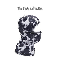 Kids balaclava with black and white cow print pattern, side view showing full hood and neck coverage