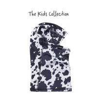Kids balaclava face mask with black and white cow print pattern, folded flat view