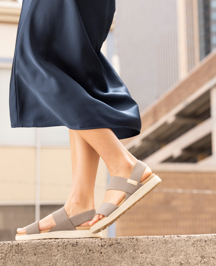 Women's backstrap sandals with elastic straps and platform sole, lifestyle shot on stone steps