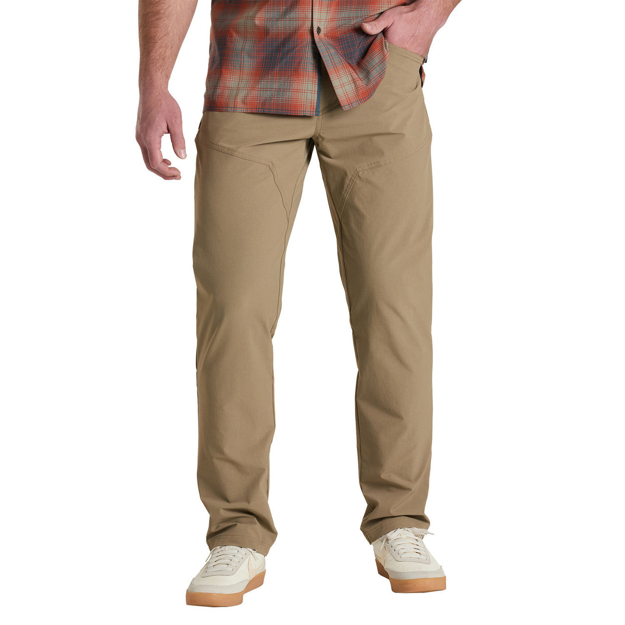 Men's khaki chino pants with clean modern fit, worn with plaid shirt and sneakers